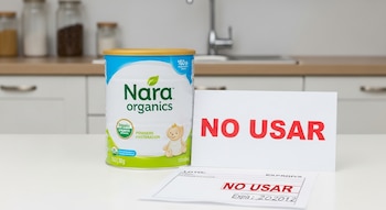 Envase de fórmula infantil Nara Organics sobre mesa blanca de cocina. Al lado, un cartel rojo grande con 'NO USAR' y una hoja con lote y fecha de vencimiento.