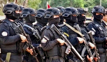Agentes con uniforme táctico negro, casco, pasamontañas, chaleco e insignia DGCIM sostienen fusiles