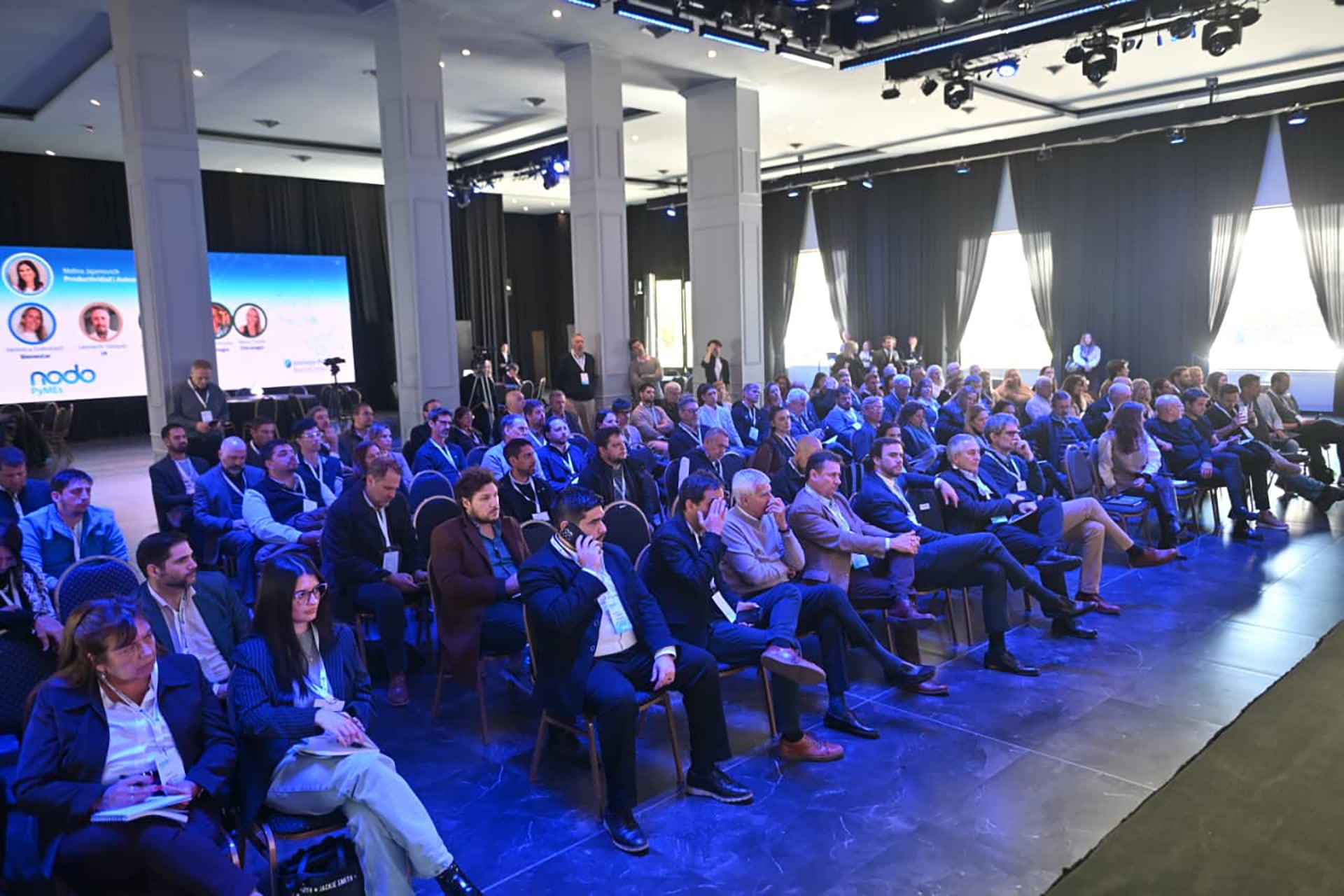 Un público numeroso escucha las ponencias en un salón durante una conferencia sobre el sector de las pequeñas y medianas empresas