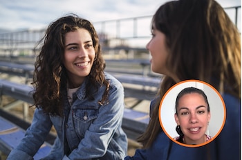 Dos mujeres jóvenes hablando, una de ellas sonriendo