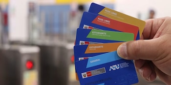 Mano sostiene varias tarjetas de transporte azul con franjas amarillo, rojo, verde, naranja y celeste. Se leen textos como 'Pase Libre', 'Estudiante', 'General'
