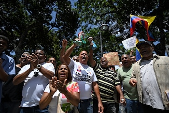 Los trabajadores sindicalizados corean consignas mientras sostienen huesos de vaca durante una manifestación en la que reclaman mejores condiciones laborales y elecciones presidenciales, frente a la Fiscalía General de la República en Caracas, el 9 de junio de 2026 (Maxwell BRICENO / AFP)
