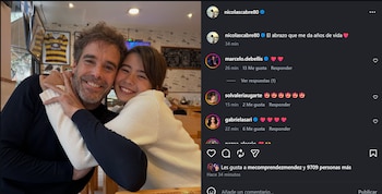 Un hombre de mediana edad con barba y una niña joven con cabello oscuro se abrazan y sonríen a la cámara, vestidos con suéteres, dentro de un local
