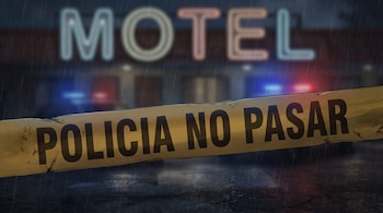 Cinta policial amarilla con la inscripción POLICIA NO PASAR delante de un letrero desenfocado de un motel con luces nocturnas.
