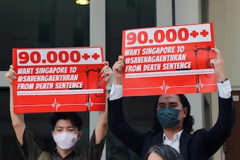 Activists hold up placards against