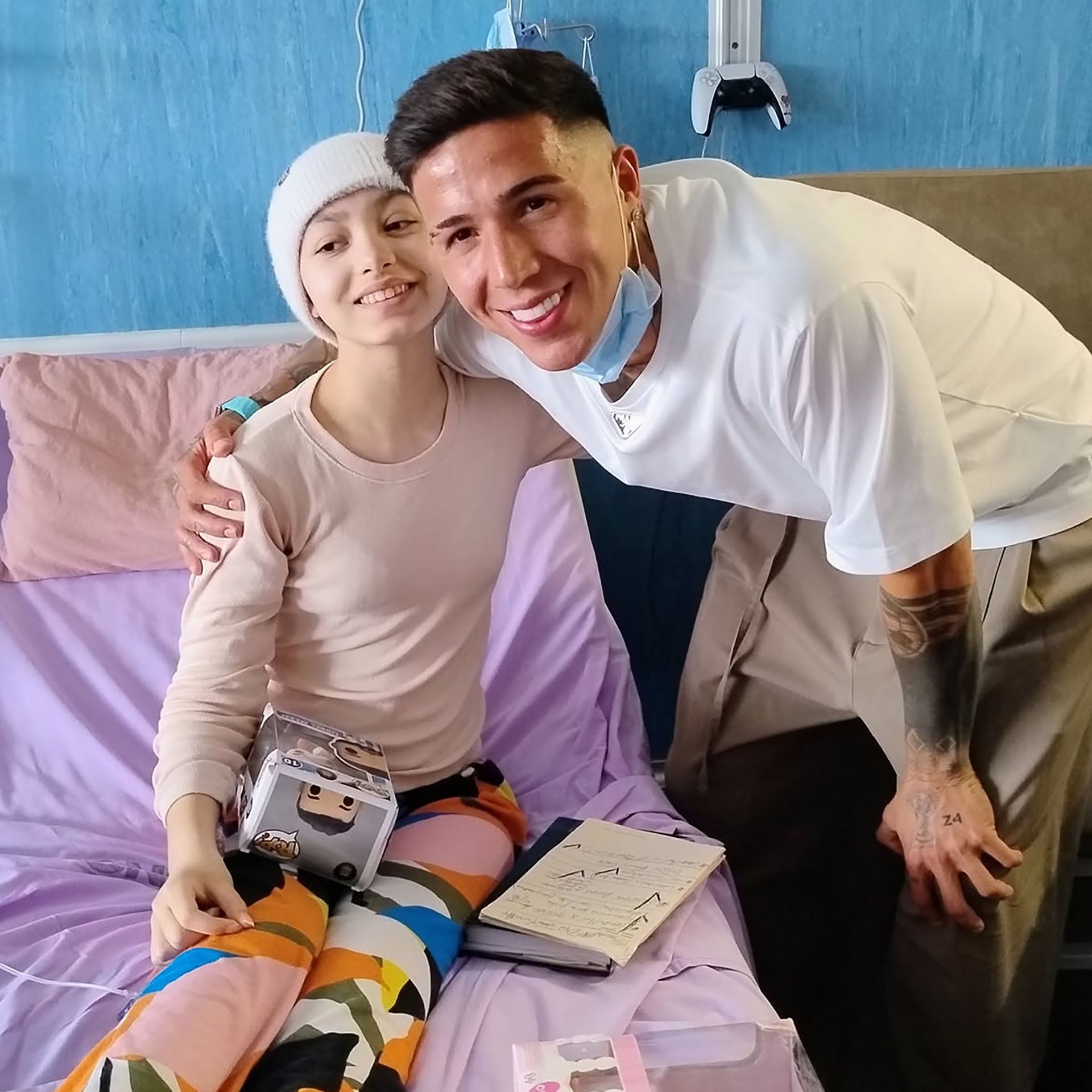 El futbolista argentino Enzo Fernández acompaña a una joven paciente durante una visita en una habitación de hospital.