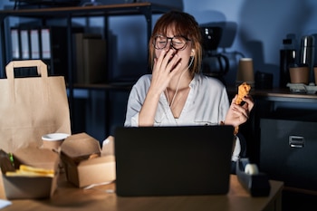 Mujer cenando tarde (Shutterstock)