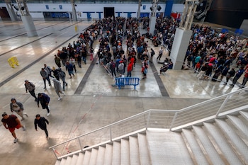 Centenares de personas migrantes vuelven a hacer cola desde primera hora de este martes en el recinto ferial La Farga de L'Hospitalet de Llobregat (Barcelona) para conseguir los documentos que faciliten su regularización en España, en el marco del proceso extraordinario abierto por el Gobierno, a 21 de abril de 2026. (EFE/ Quique García)
