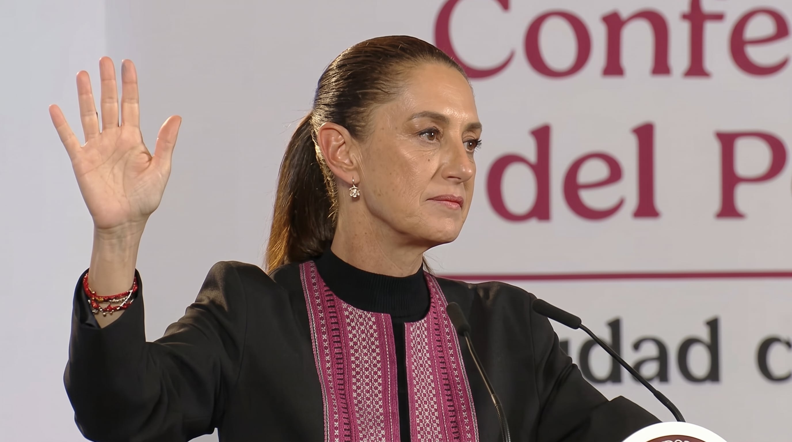 Claudia Sheinbaum levanta la mano derecha durante un mensaje ante los medios de comunicación. (Imagen Ilustrativa Infobae)
