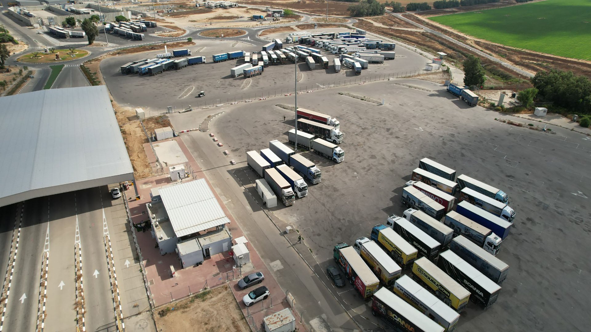 Decenas de camiones de carga permanecen estacionados junto a las cabinas de control en una terminal de transporte en Israel