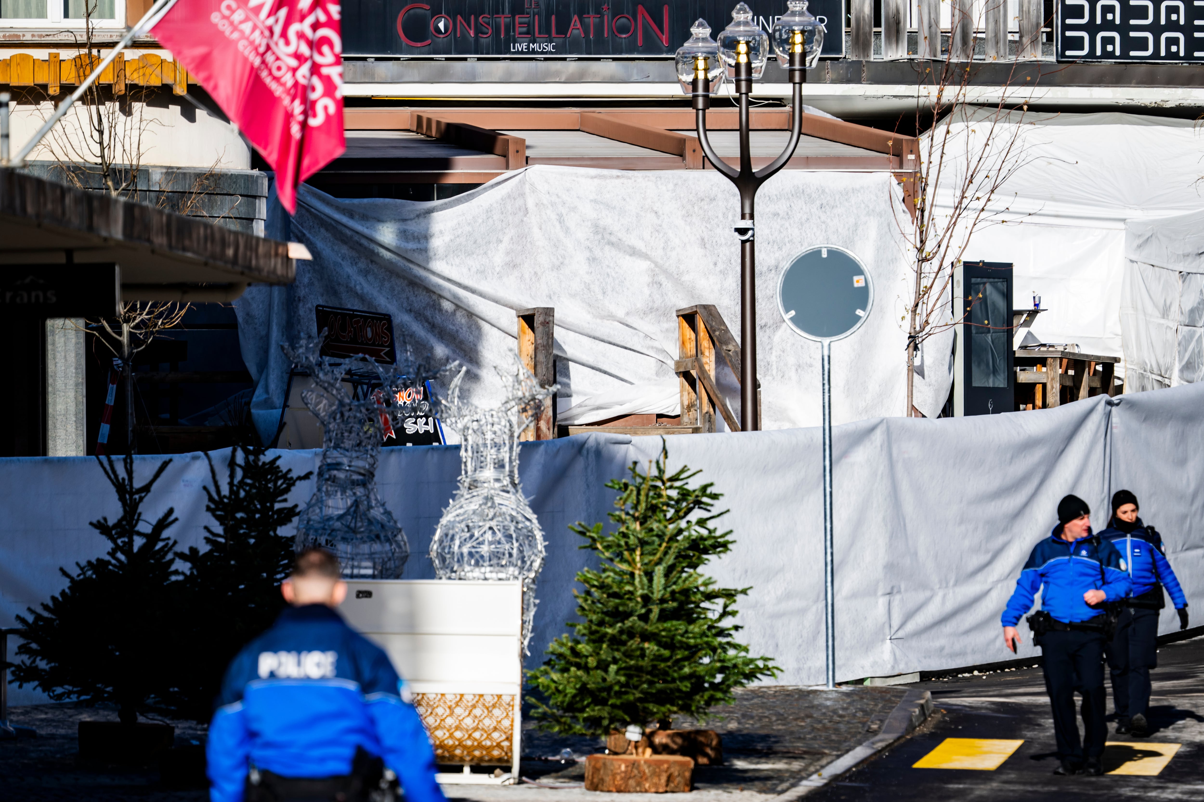 Policías inspeccionan el área del bar Le Constellation, donde el fuego causó decenas de muertos y más de 100 heridos durante la celebración de Año Nuevo. (Jean-Christophe Bott/Keystone via AP)