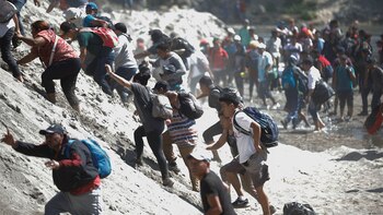 Migrantes escalan las riberas del