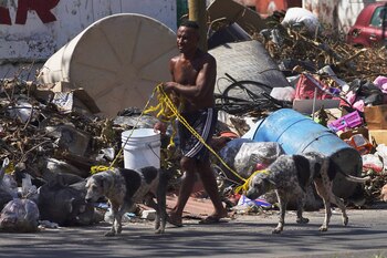 Un residente camina junto a escombros tras la devastación que dejó el paso del huracán Otis, en Acapulco, México, el domingo 12 de noviembre de 2023. Cerca de tres semanas después de que el ciclón de categoría 5 destrozara el puerto del océano Pacífico, dejando 48 personas muertas y la infraestructura de la ciudad hecha pedazos, las tareas de limpieza siguen pendientes. (AP Foto/Marco Ugarte)