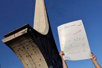 Un joven sirio sostiene un cartel que dice "Constitución, libertad, un estado civil, ni ejército ni religión" durante una manifestación junto a la Ópera de Damasco en la Plaza Omeya, después de que Bashar al-Assad fuera derrocado, en Damasco, Siria, el 19 de diciembre (REUTERS/Amr Abdallah Dalsh)