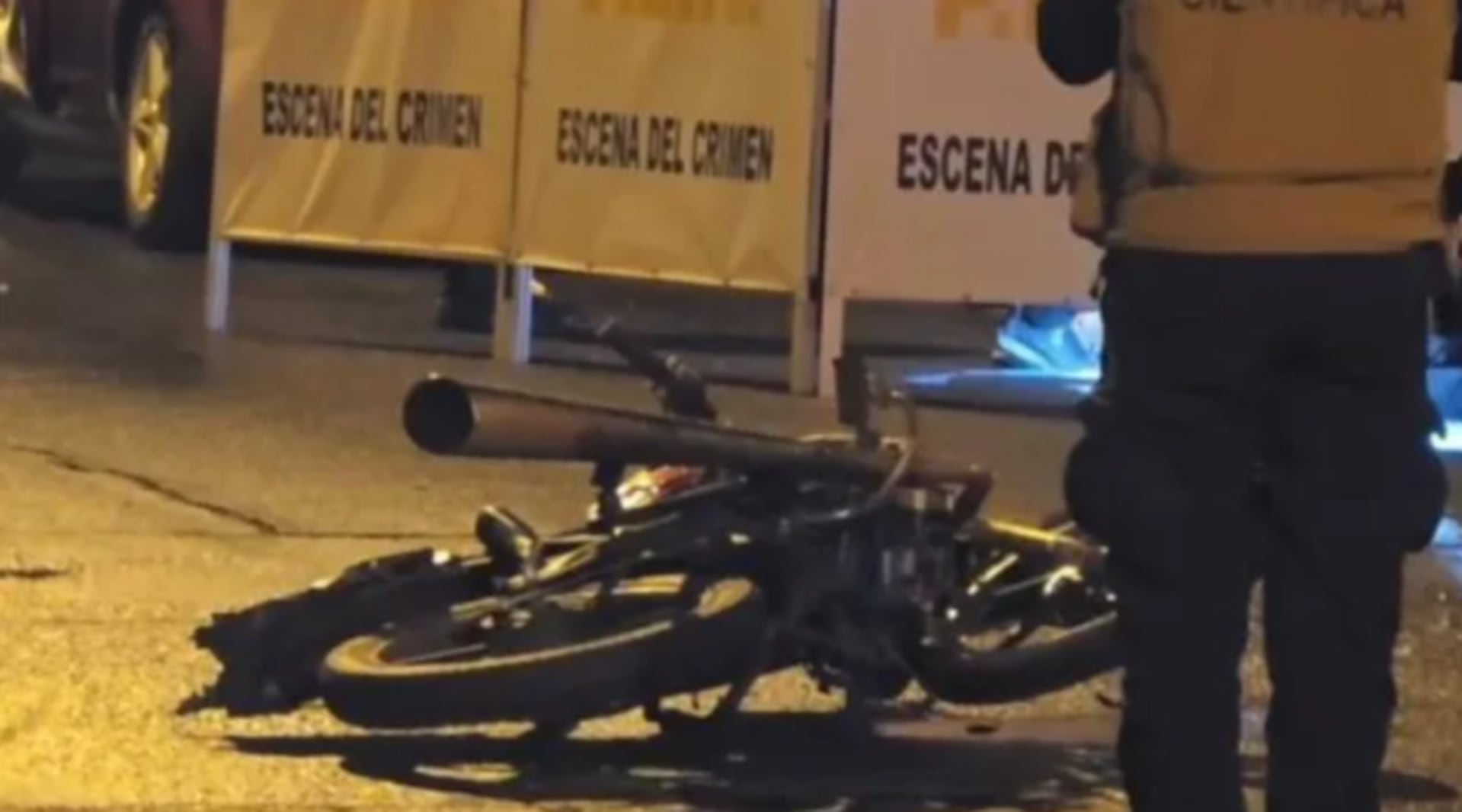 Una motocicleta yace en el asfalto junto a barreras de