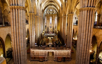 El coro de madera tallada y los vitrales policromados dominan el interior de la Catedral de la Santa Cruz y Santa Eulalia