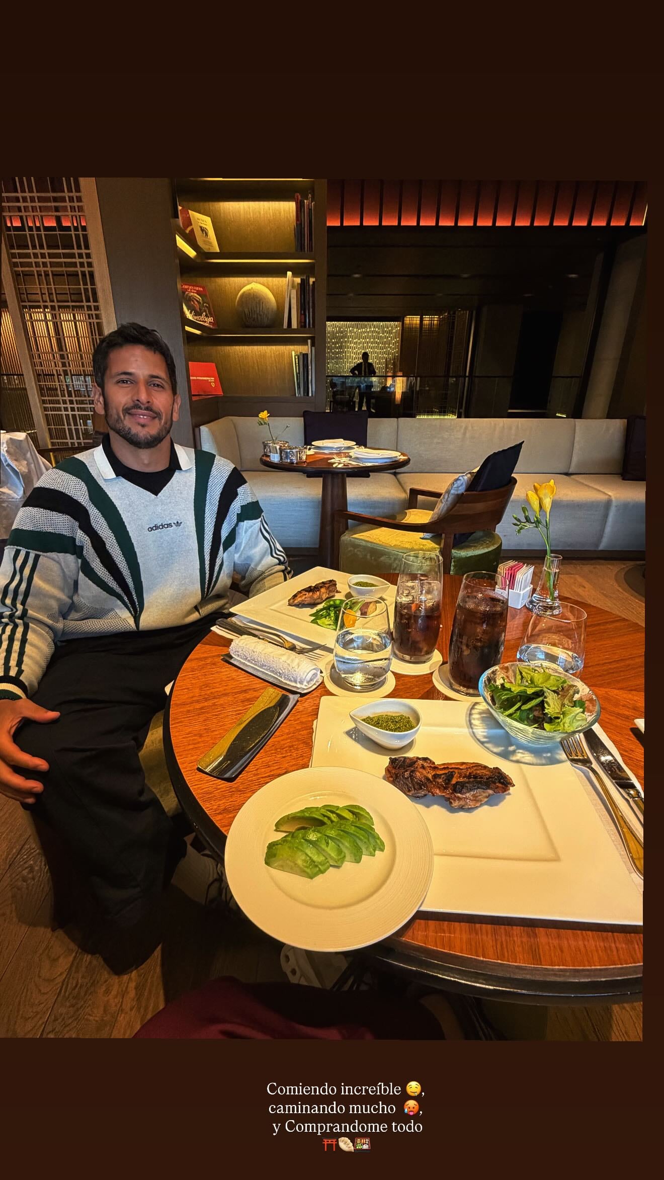 Martín Migueles posa sonriente en un restaurante de Kyoto, donde disfruta de una deliciosa cena con aguacate, carne y ensalada durante su travesía por la ciudad japonesa.