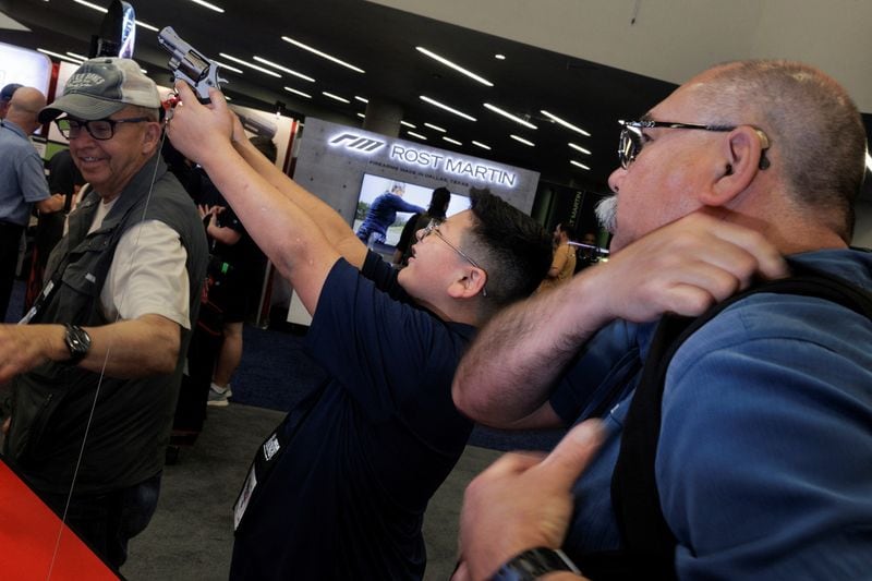 Un adolescente sostiene un arma en un stand de exhibición durante la reunión anual de la Asociación Nacional del Rifle (NRA) en Dallas, Texas, EEUU, el 18 de mayo de 2024. REUTERS/Shelby Tauber