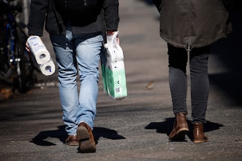 Dos personas con bolsas de papel higiénico. REUTERS/Michele Tantussi
