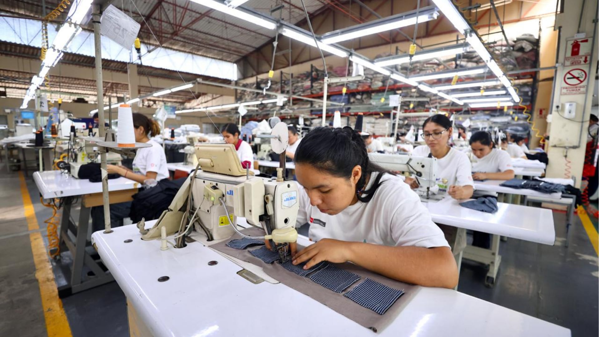 Varias operarias confeccionan prendas de vestir en un taller textil industrial, en el marco de las discusiones sobre la formalización del empleo en Perú.
