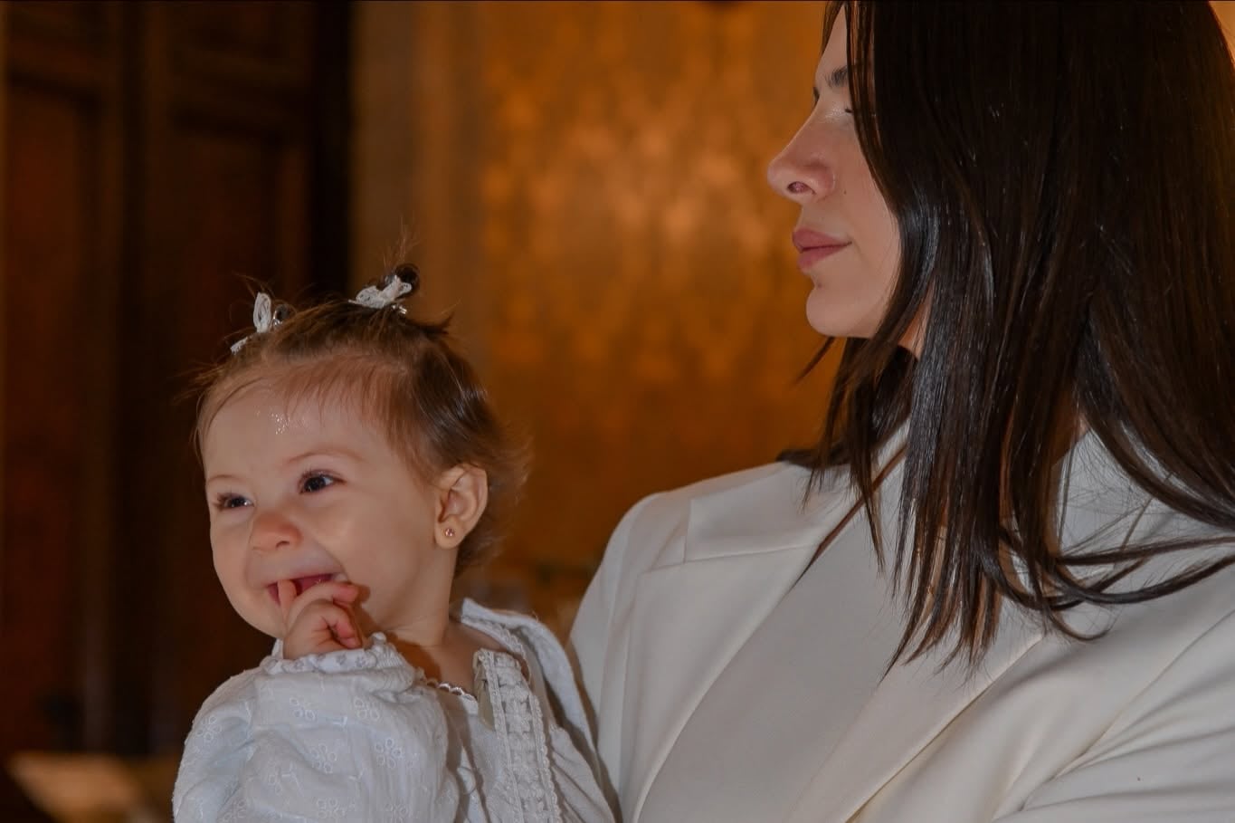 Ailén Cova sostiene en brazos a la pequeña Alaia durante la ceremonia religiosa