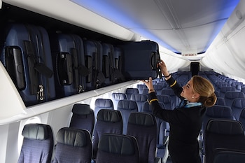 Una azafata abriendo las cabinas