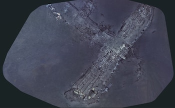 Restos dispersos y fragmentados de una aeronave sobre un lecho marino oscuro de textura desigual y con algunos sedimentos