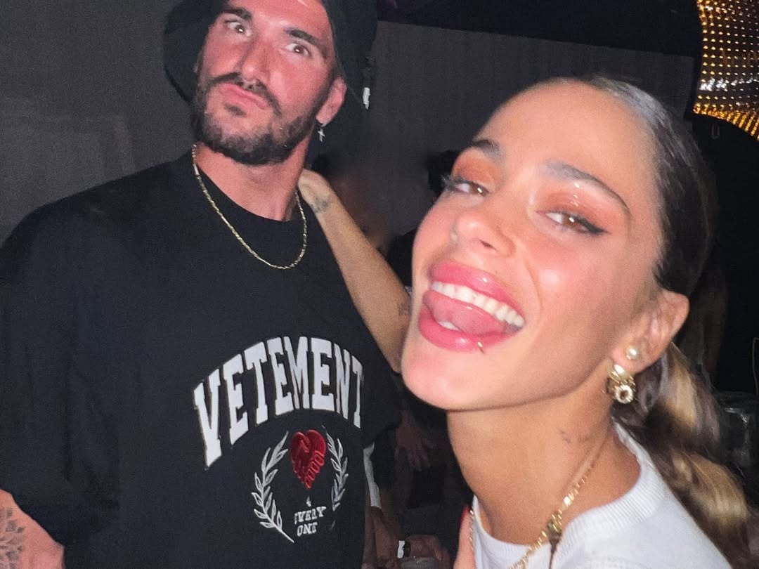 La pareja en una noche de fiesta: Tini en primer plano y Rodrigo de fondo