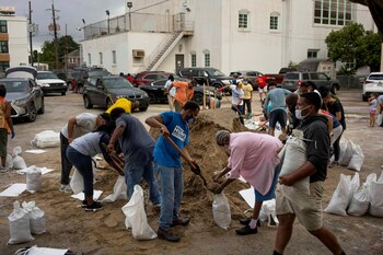 Personas llenan sacos de arena