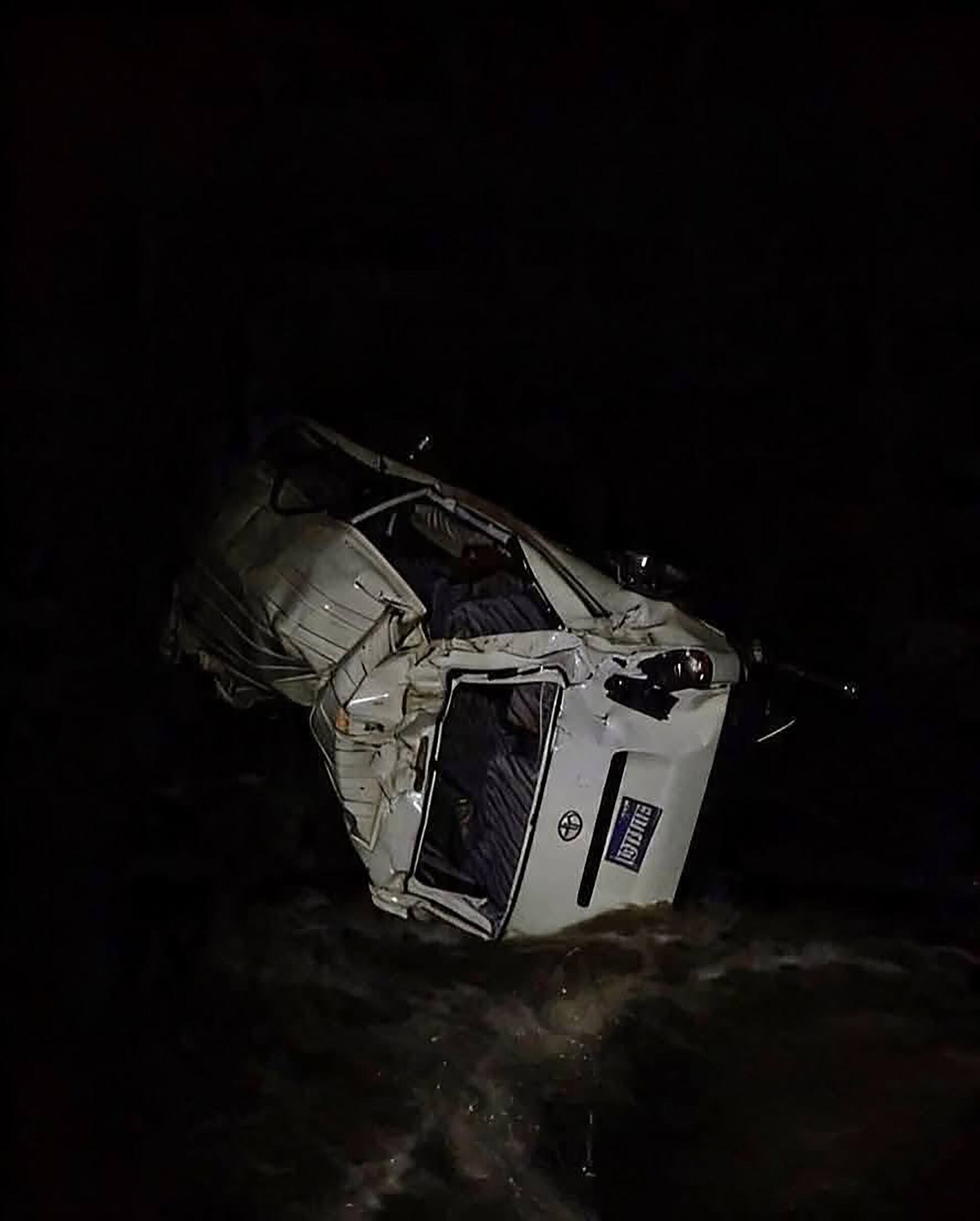 Un vehículo blanco yace volcado y parcialmente sumergido en aguas oscuras tras un grave accidente ocurrido durante la noche. (Bomberos Departamentales de Guatemala)