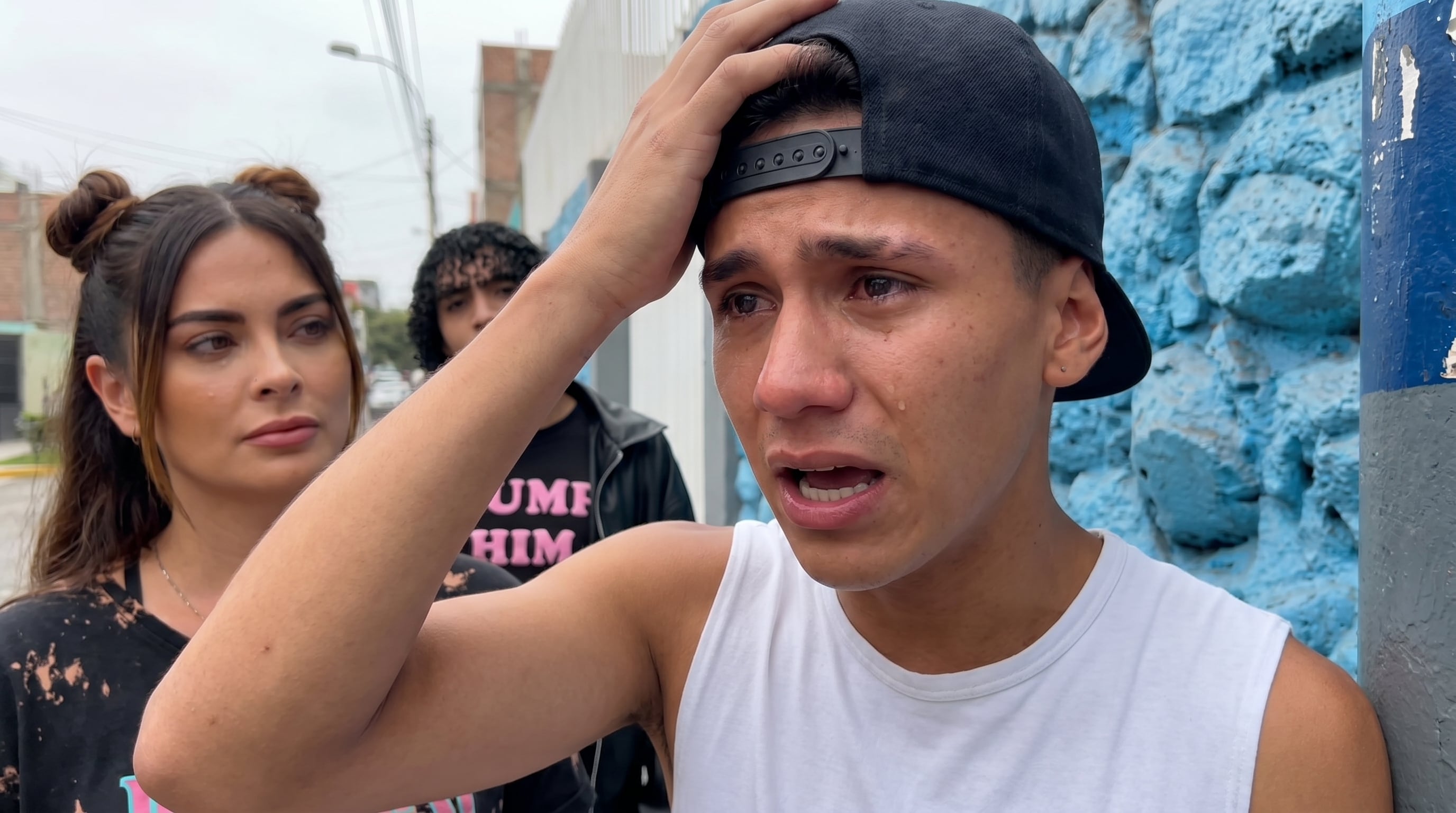 Sebastián Gálvez, visiblemente afectado y con lágrimas, expresa su angustia ante la cámara por la controversia con Valentino, mientras una mujer lo acompaña y Valentino observa en segundo plano. (Imagen Ilustrativa Infobae)