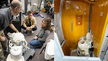 Christina Koch y dos hombres observan un inodoro espacial blanco. A la derecha, un inodoro espacial instalado en un compartimento revestido de amarillo
