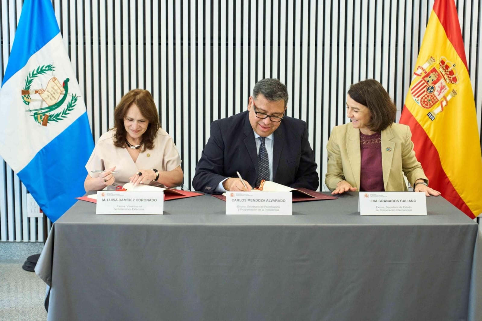 Altos funcionarios de Guatemala y España, incluyendo a la Viceministra de Relaciones Exteriores y al Secretario de Estado de Cooperación Internacional, firman documentos en una mesa. (Ministerio de Relaciones Exteriores de Guatemala)