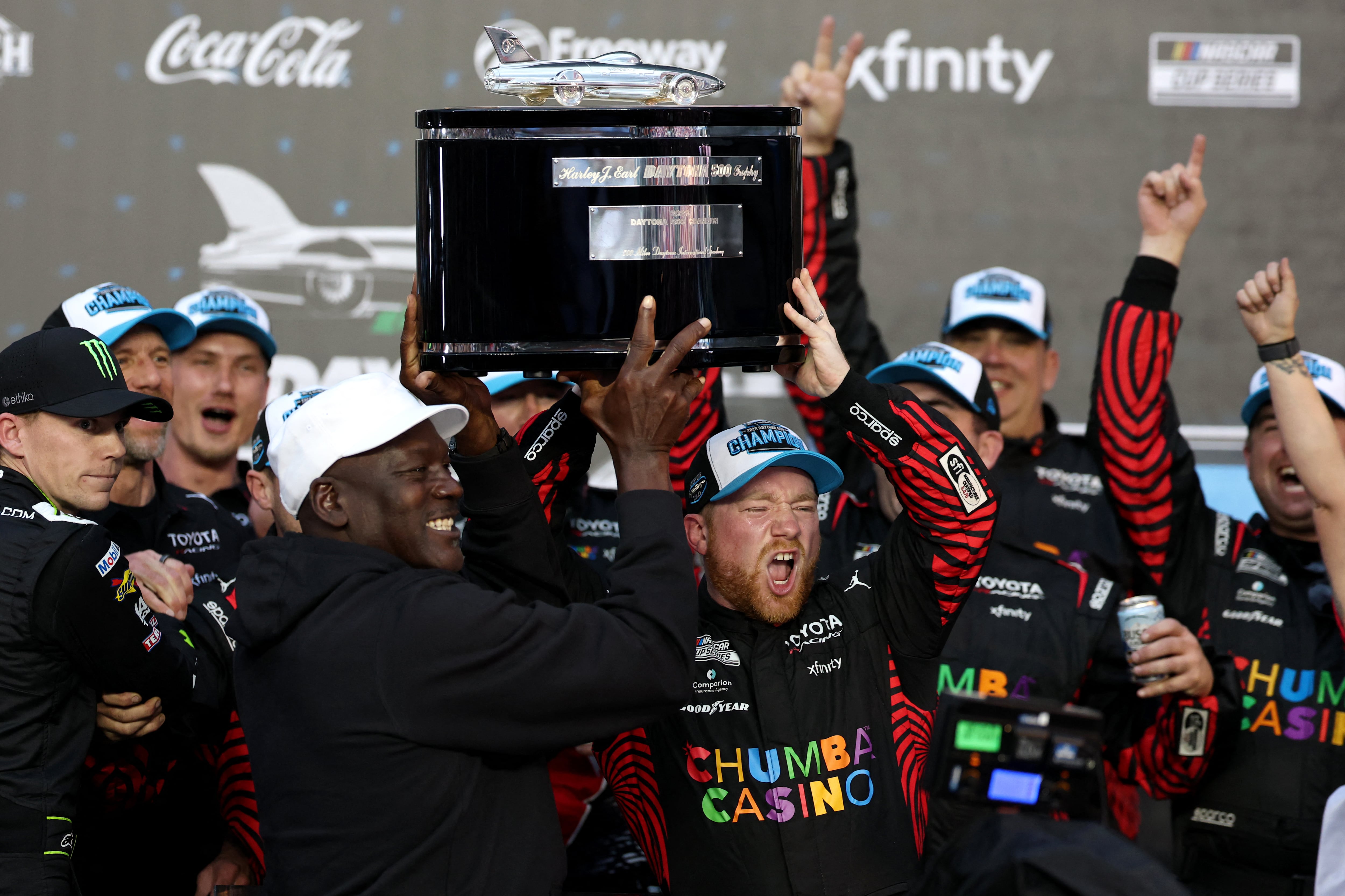 Tyler Reddick levanta el trofeo junto con Michael Jordan (Photo by Chris Graythen / GETTY IMAGES NORTH AMERICA / Getty Images via AFP)