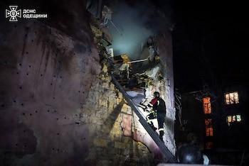 Un bombero subiendo una escalera en busca de supervivientes tras un ataque ruso a un edificio residencial en Odesa, en el contexto de la invasión rusa de Ucrania (AFP)