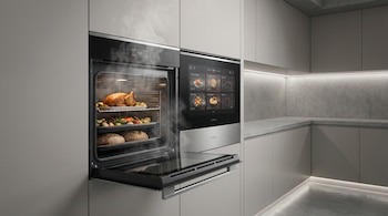 Horno inteligente integrado, puerta abierta mostrando pollo, verduras y pan horneándose. Vapor emerge de la cavidad. Pantalla táctil visible al lado.