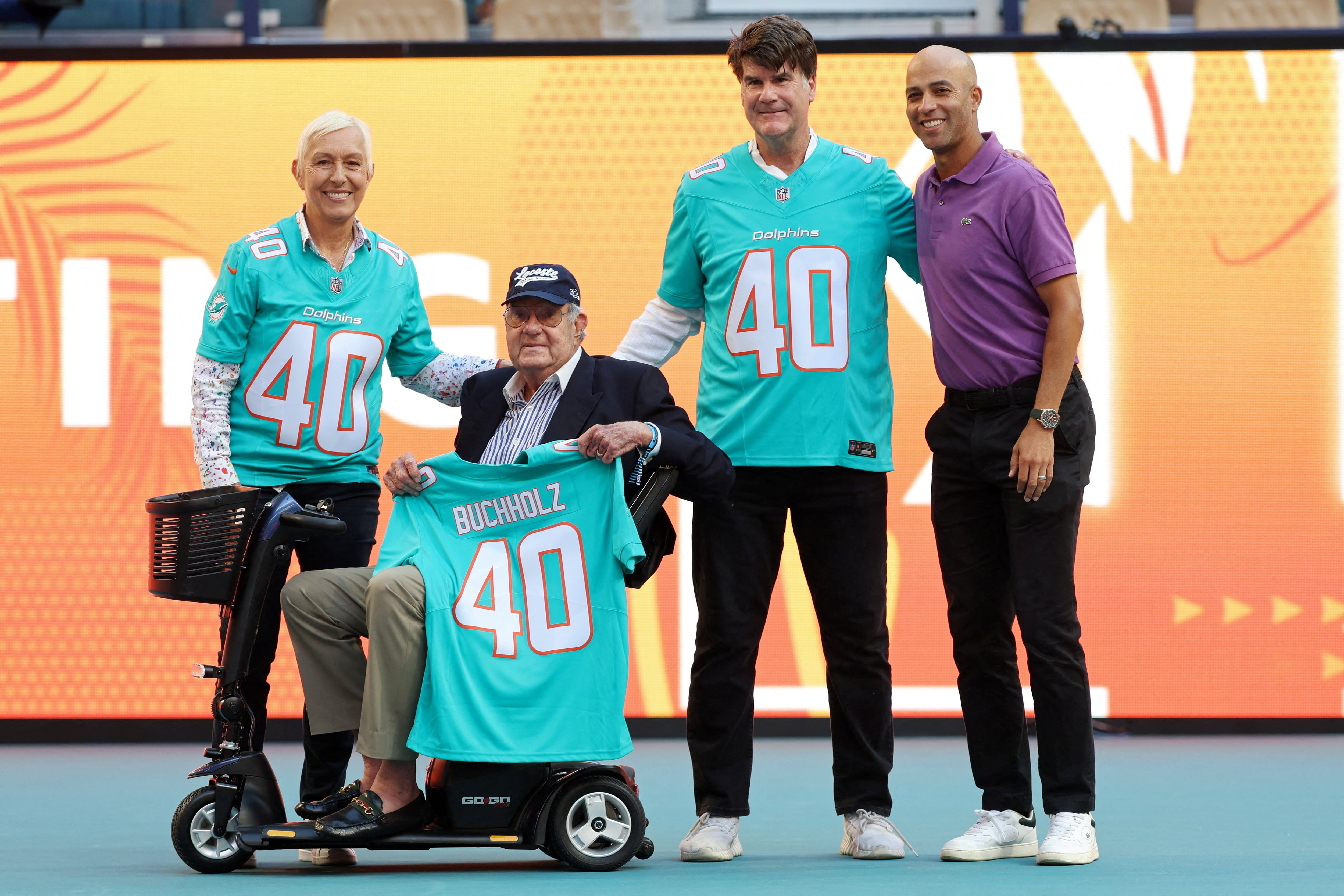 Butch Buchholz, creador del torneo, posa con la camiseta de los Miami Dolphins junto a los primeros campeones, Martina Navratilova y Tim Mayotte. A la derecha, James Blake, director del certamen (Fuente: Reuters)