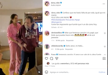Una mujer con pijama rosa y un hombre con una sudadera de Barcelona están de pie en una habitación, la mujer toca la espalda del hombre