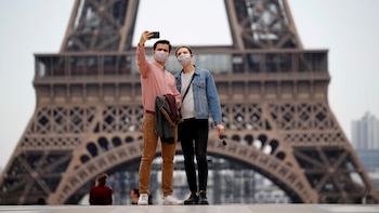 Dos personas con mascarillas se