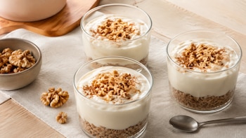 El pay de nuez saludable se prepara sin horno con una base de avena y un relleno cremoso de yogur griego; se decora con nueces picadas y canela