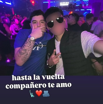 Dos hombres posan en un local nocturno con luces violetas, sobre una franja oscura con el texto «hasta la vuelta compañero te amo» y tres emoticonos