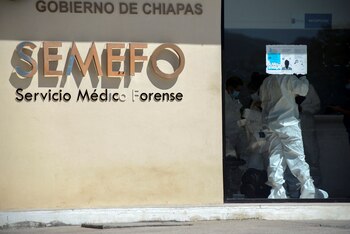 Forensic technicians stand inside the