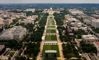 Vista aérea del National Mall con el Capitolio de Estados Unidos, edificios, árboles, áreas verdes, un escenario y una noria