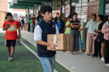 Fotografía del lunes 13 de abril de 2026 que muestra a un integrante de la Oficina Nacional de Procesos Electorales (ONPE) que carga una caja para empezar la instalación de una de las mesas de votación en el colegio Señor de los Milagros, en el distrito de Lurín (Perú). EFE/ John Reyes Mejía
