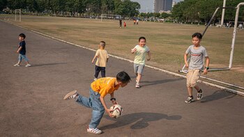 Algunos niños juegan futbol en