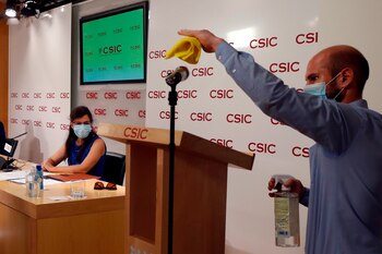 MADRID, 07/07/2020.- Un asistente desinfecta el micrófono mientras a investigadora Mar Valés (i) da una rueda de prensa, junto al equipo de investigadores, los jefes de Inmunología de los hospitales y los directivos de la empresa, este martes en la sede del Consejo Superior de Investigaciones Científicas (CSIC) en Madrid, para presentar un nuevo test serológico de detección de anticuerpos de SARS-COV-2 desarrollado por investigadores del CNB-CSIC, validado por hospitales madrileños y que será producido por una empresa española en el plazo de un mes y medio . EFE/J.J. Guillén