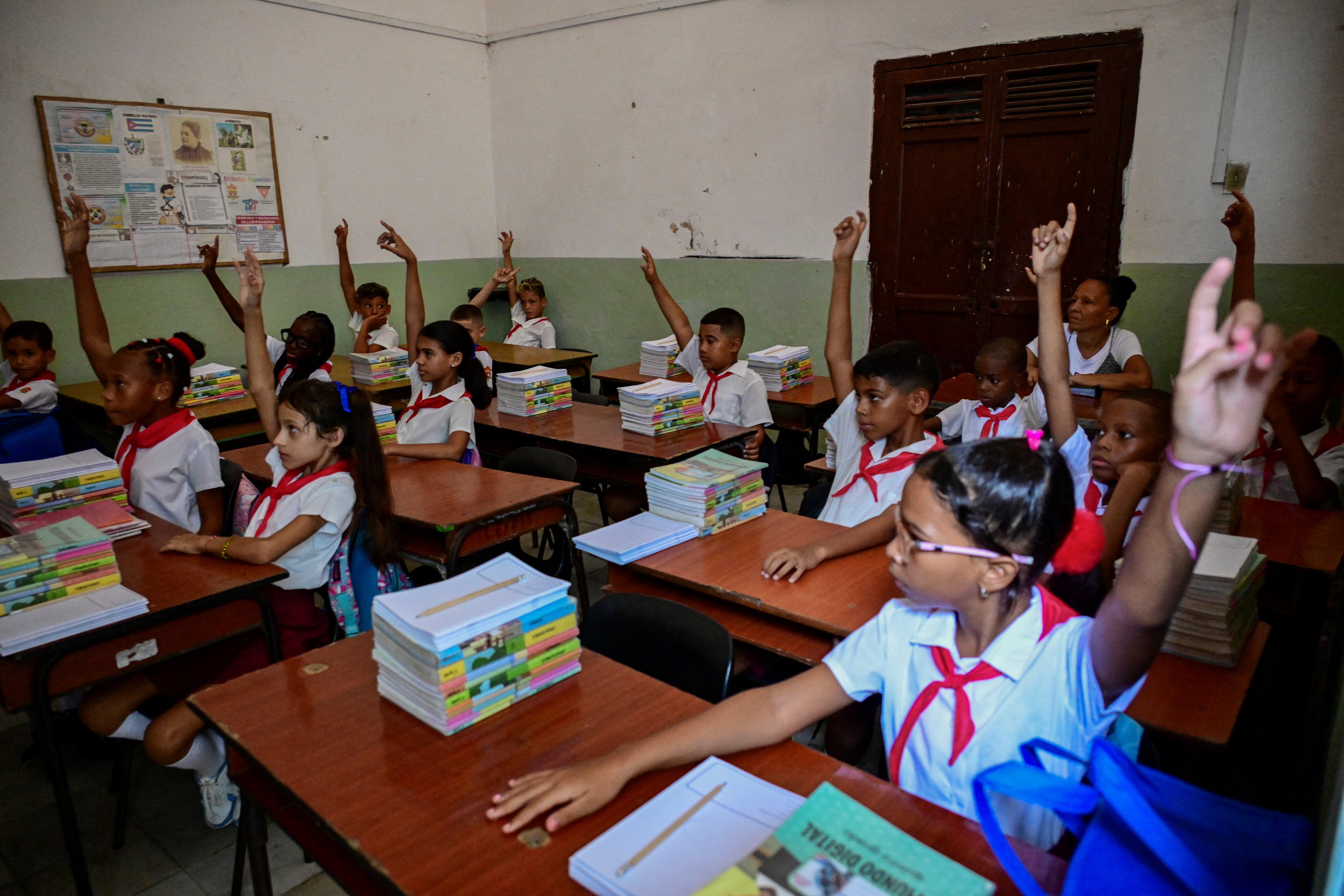 Los estudiantes hacen el saludo escolar antes de entrar a sus aulas en el primer día del año académico 2026-2027 en La Habana, el 1 de septiembre de 2026. En medio de la escasez de uniformes y de maestros, así como de prolongados cortes de electricidad, 1,4 millones de estudiantes iniciaron un nuevo curso escolar el 1 de septiembre en Cuba, donde la crisis económica obliga a las familias a asumir los crecientes costos de la educación de sus hijos. (Infobae Cuba/ YAMIL LAGE / AFP)