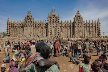 La Gran Mezquita de Djenné, en Malí, es el edificio de barro más grande del mundo y centro de un festival anual de restauración comunitaria (Photo by OUSMANE MAKAVELI / AFP)