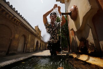 Un joven se refresca en una fuente de del Patio de los Naranjos de la Mezquita-Catedral de Córdoba. La primera ola de calor que afecta a España este verano llega a su fin este miércoles con valores aún muy altos, hasta 42 grados, sobre todo en el centro y sur peninsular, aunque ya sin superar los umbrales establecidos para estos episodios de calor extremo. (EFE/Salas)