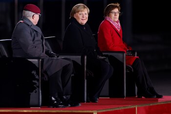 Merkel sonríe rodeada de la